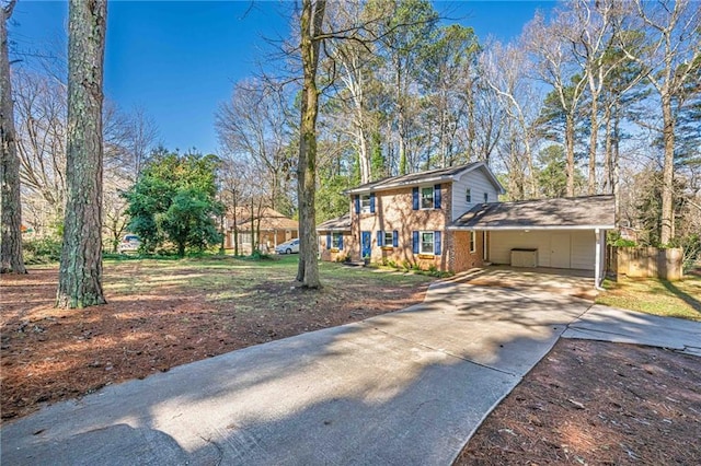 view of front of home featuring brick siding, concrete driveway, and fence