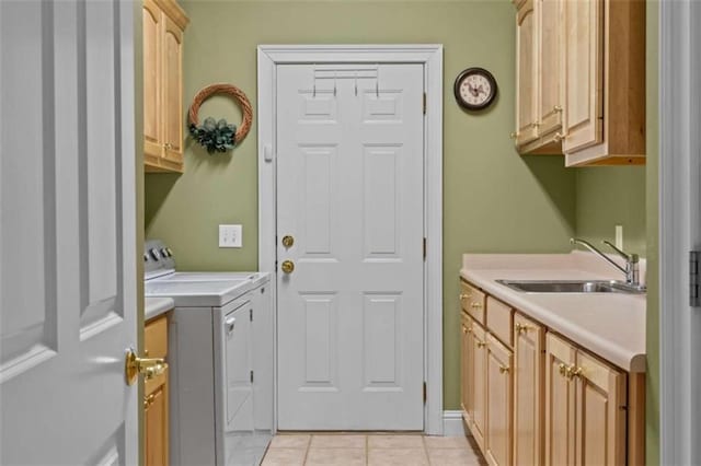 laundry area with light tile patterned flooring, cabinets, washer and dryer, and sink