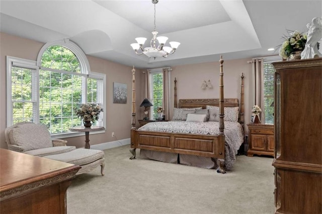 bedroom with a raised ceiling, light carpet, and multiple windows