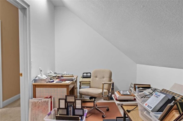 office space featuring lofted ceiling, light colored carpet, and a textured ceiling