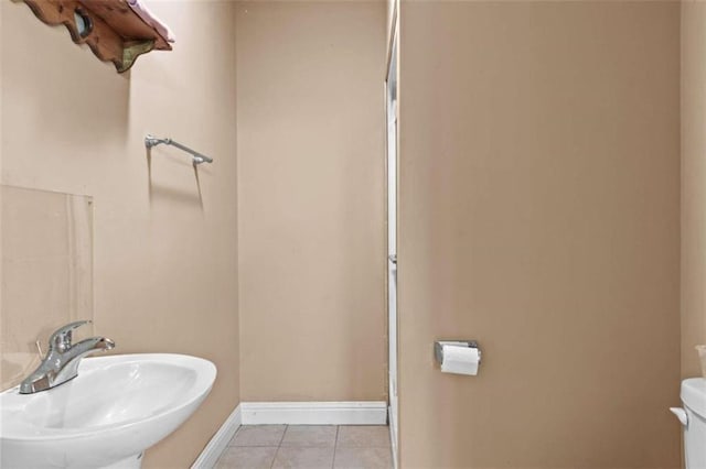 bathroom with tile patterned flooring, toilet, and sink