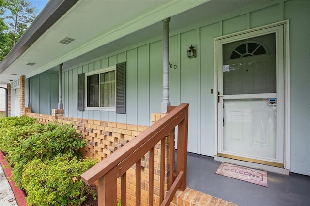 1960 Oak Leaf Ct SW, Marietta, GA 30008 - doorway to property with board and batten siding, a porch, and brick siding
