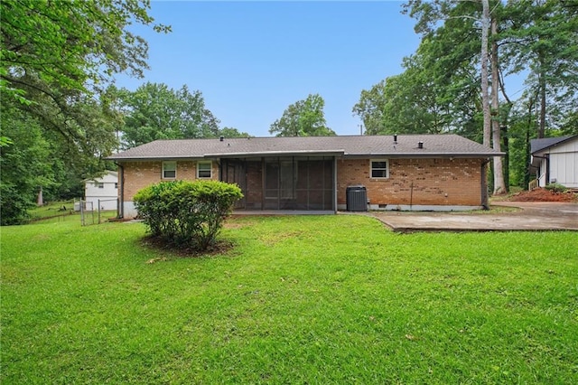 1960 Oak Leaf Ct SW, Marietta, GA 30008 - back of property featuring central air condition unit, a sunroom, a yard, and brick siding