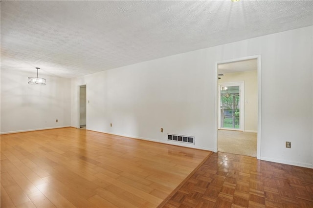 1960 Oak Leaf Ct SW, Marietta, GA 30008 - spare room featuring a chandelier, a textured ceiling, and baseboards