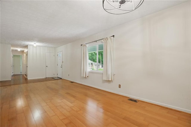 1960 Oak Leaf Ct SW, Marietta, GA 30008 - unfurnished room with light wood finished floors, baseboards, and a chandelier