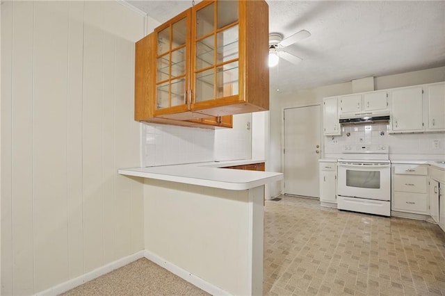 1960 Oak Leaf Ct SW, Marietta, GA 30008 - kitchen with white electric range, under cabinet range hood, light countertops, ceiling fan, and a peninsula