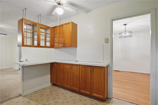 1960 Oak Leaf Ct SW, Marietta, GA 30008 - kitchen with brown cabinetry, ceiling fan, glass insert cabinets, light countertops, and baseboards