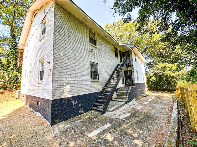 1152 Greenwich St SW, Atlanta, GA 30310 - view of side of property with crawl space, brick siding, stairway, and fence