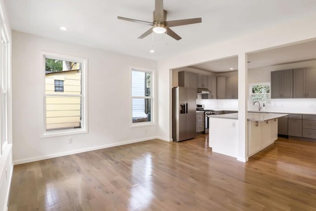 kitchen with appliances with stainless steel finishes, a kitchen island, and a healthy amount of sunlight