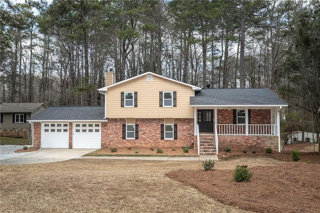 split level home with driveway, a chimney, an attached garage, a porch, and brick siding