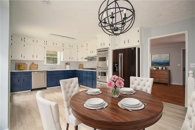 dining area featuring light wood-style flooring and a notable chandelier