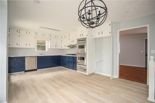 kitchen with stainless steel appliances, blue cabinets, a sink, and white cabinetry