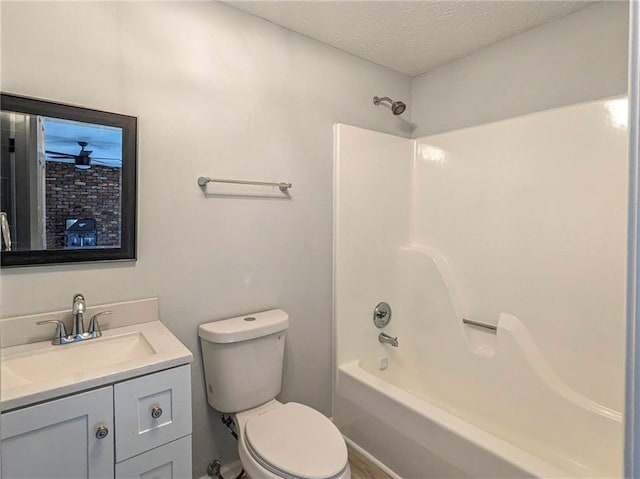 full bath with a textured ceiling, shower / bathtub combination, vanity, and toilet