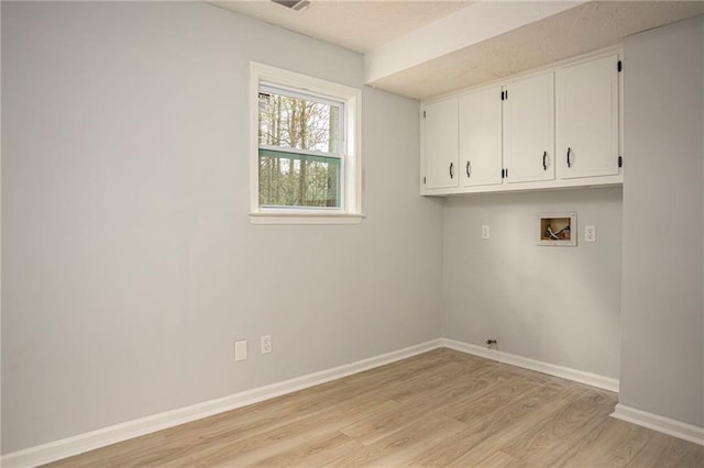 laundry room with cabinet space, baseboards, hookup for a washing machine, a textured ceiling, and light wood-style floors