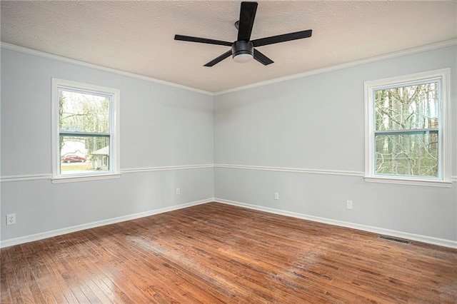 unfurnished room with hardwood / wood-style flooring, visible vents, and ornamental molding