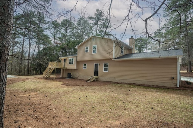 back of property featuring entry steps, central AC, stairs, a yard, and a chimney