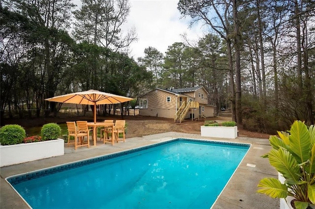 pool with stairway and a patio