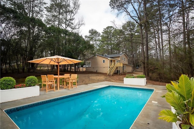 pool with a patio and stairway