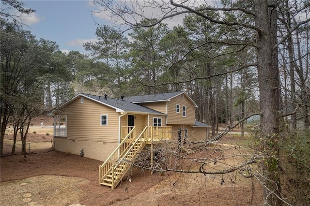 back of house with crawl space, stairs, fence, and roof with shingles