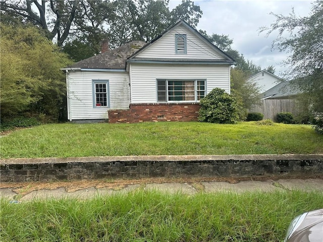 rear view of property with a chimney, crawl space, fence, a yard, and brick siding