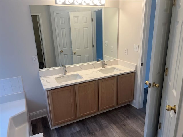 2682 Field Spring Dr, Lithonia, GA 30058 - bathroom with wood finished floors, double vanity, a tub, and baseboards