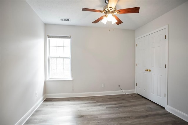 2682 Field Spring Dr, Lithonia, GA 30058 - unfurnished bedroom featuring wood finished floors, baseboards, ceiling fan, and a closet