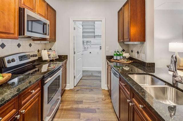 325 E Paces Ferry Rd NE Unit 410, Atlanta, GA 30305 - kitchen with appliances with stainless steel finishes, light wood finished floors, a sink, decorative backsplash, and dark stone counters