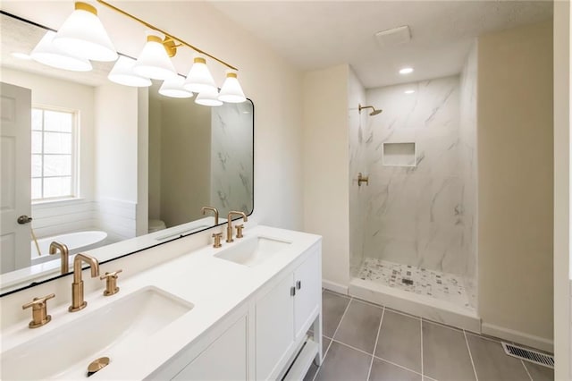 bathroom featuring a marble finish shower, visible vents, a sink, and tile patterned floors