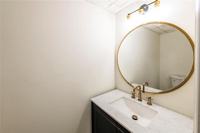 bathroom featuring a paneled ceiling and vanity