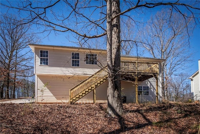 back of property featuring stairs and a wooden deck