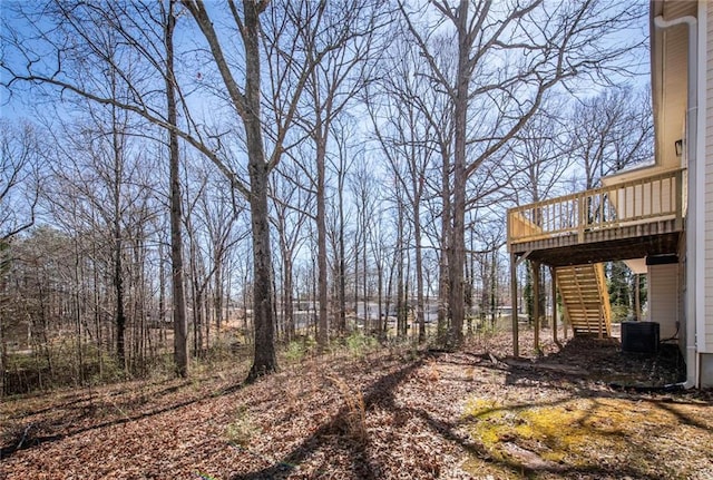 view of yard featuring stairway, cooling unit, and a wooden deck