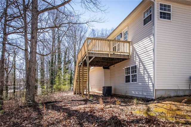 view of side of home featuring stairway, a wooden deck, and central air condition unit