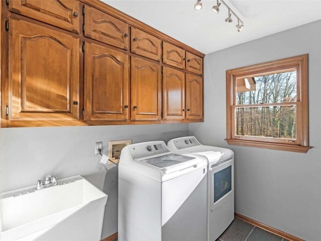 laundry area with track lighting, a sink, washing machine and dryer, baseboards, and cabinet space