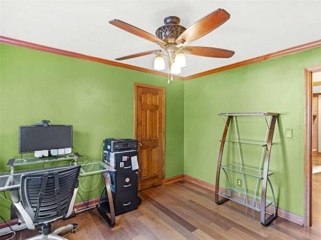 home office featuring crown molding, baseboards, a ceiling fan, and wood finished floors
