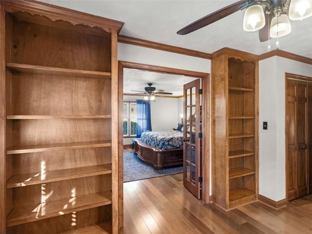 bedroom featuring ceiling fan, wood finished floors, baseboards, and ornamental molding