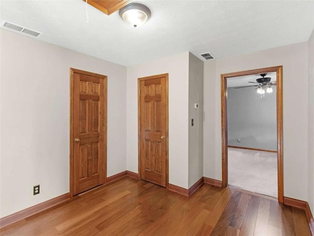 unfurnished bedroom with baseboards, visible vents, and light wood-style flooring
