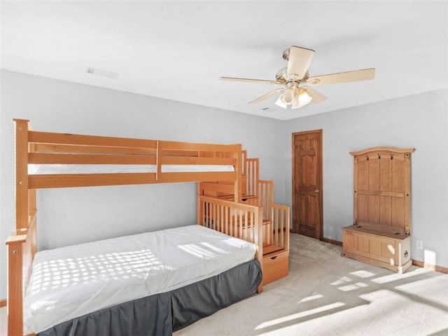 carpeted bedroom with baseboards, a ceiling fan, and visible vents