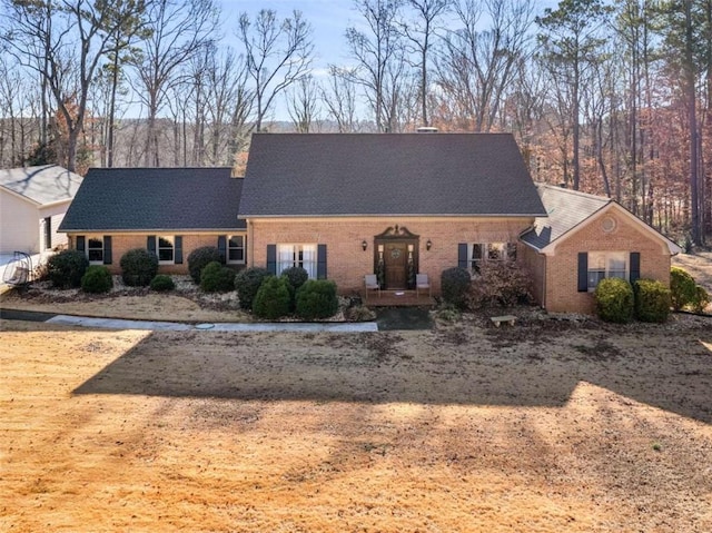 view of front of home with brick siding and a shingled roof