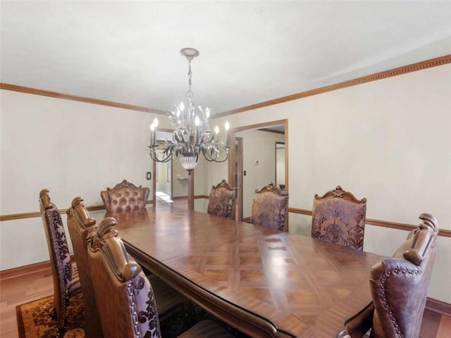 dining room featuring baseboards, wood finished floors, and a notable chandelier