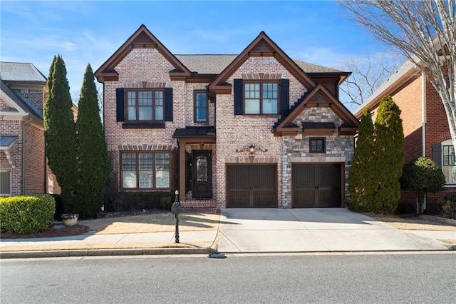 view of front of house with driveway, brick siding, an attached garage, and stone siding