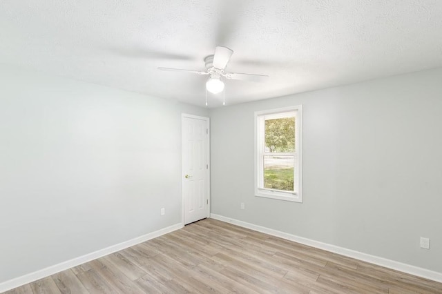 empty room featuring ceiling fan, light wood-type flooring, and a textured ceiling