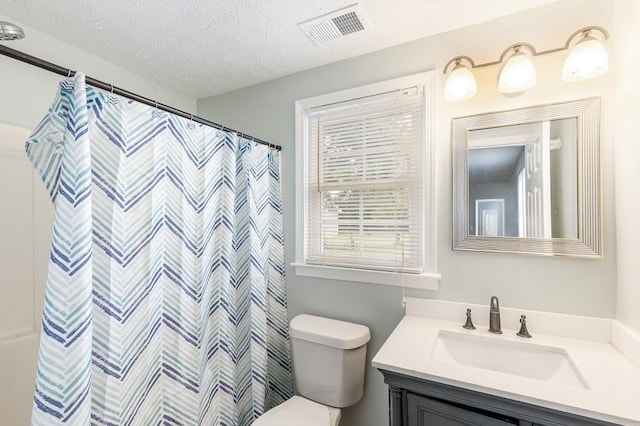 bathroom with a textured ceiling, toilet, a shower with shower curtain, and vanity