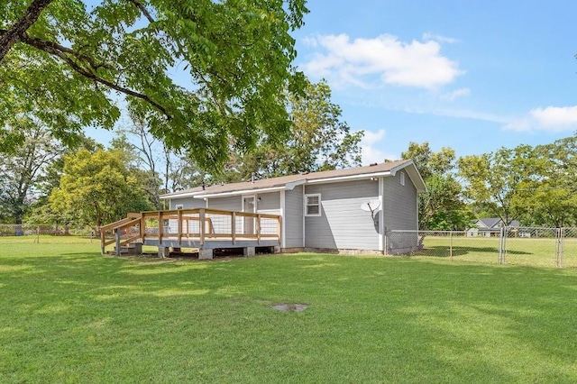 rear view of property featuring a deck and a yard