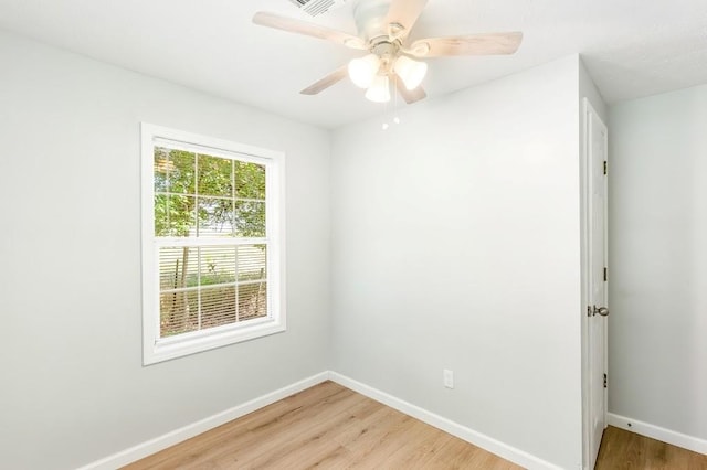 spare room with ceiling fan, a healthy amount of sunlight, and hardwood / wood-style flooring