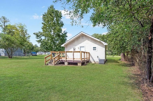 back of property with central AC, a deck, and a yard