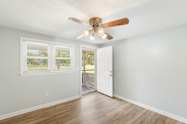 empty room with a textured ceiling, ceiling fan, and light hardwood / wood-style flooring