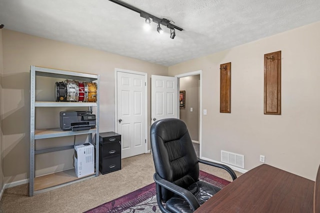 carpeted office space with track lighting and a textured ceiling