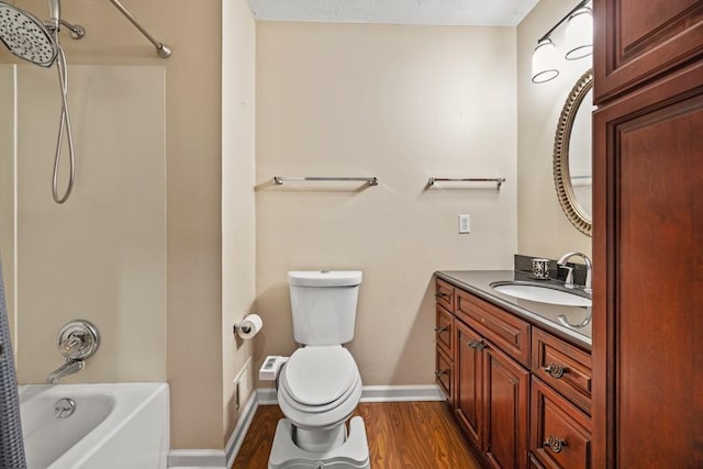 full bathroom featuring vanity, hardwood / wood-style flooring, bathtub / shower combination, and toilet