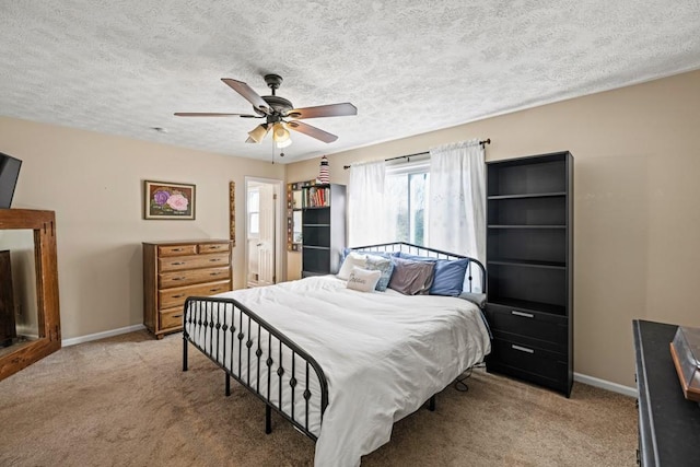 bedroom with ceiling fan, light colored carpet, and a textured ceiling