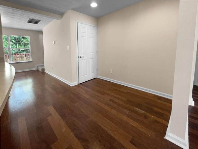 unfurnished room featuring a textured ceiling and dark wood-type flooring